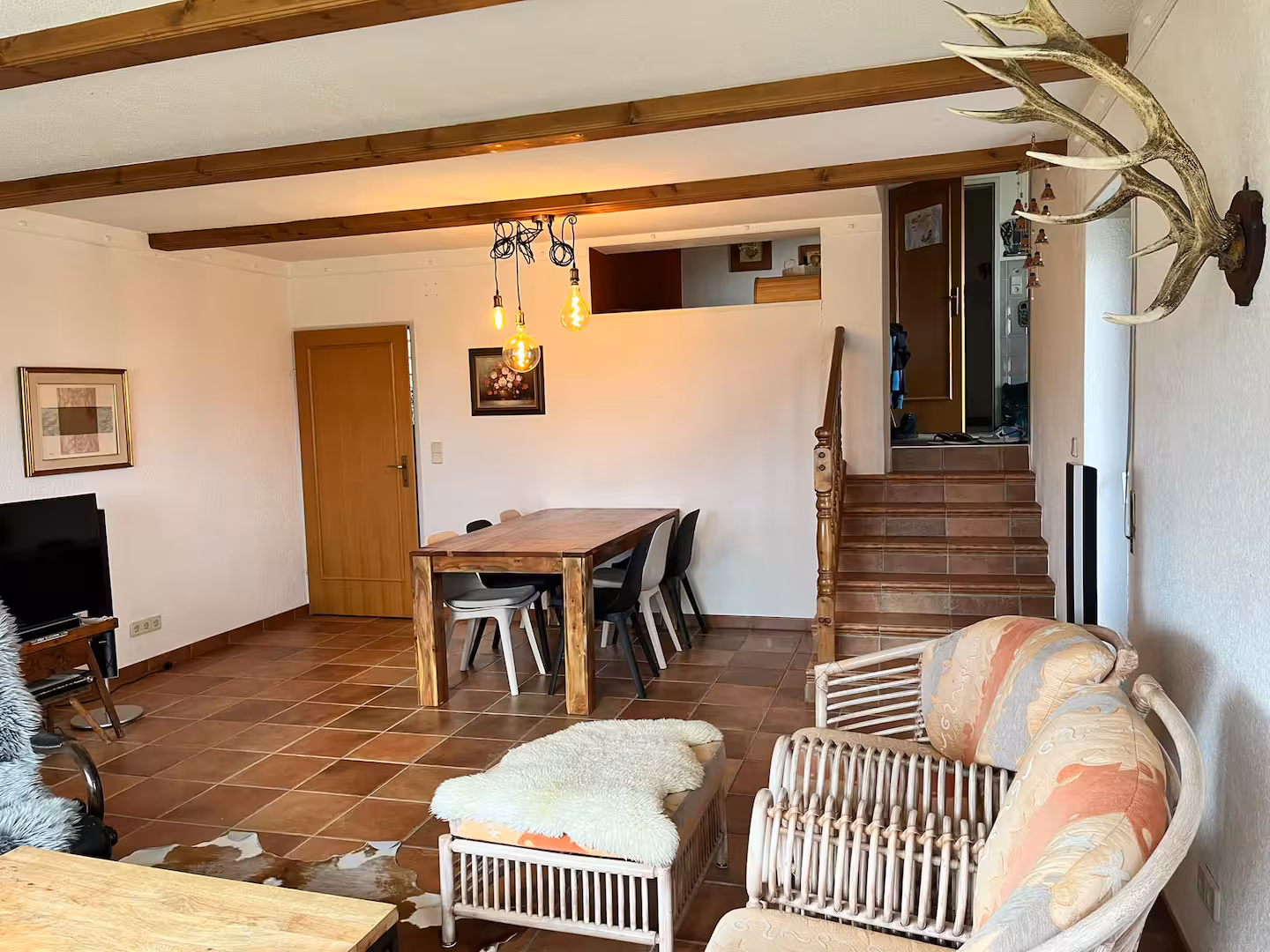 Wohn- und Essbereich mit Holztisch und Treppe